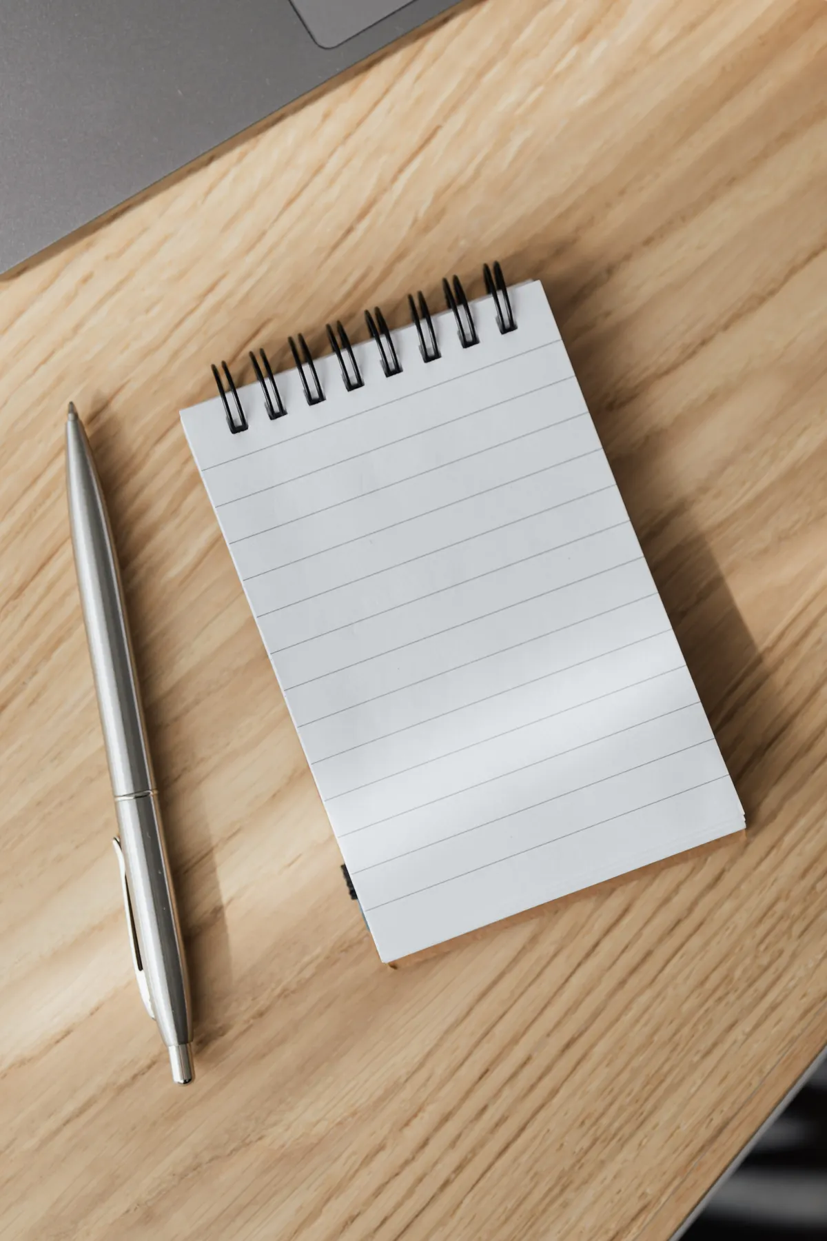 Sample image: A blank notebook and pen on a wooden desk